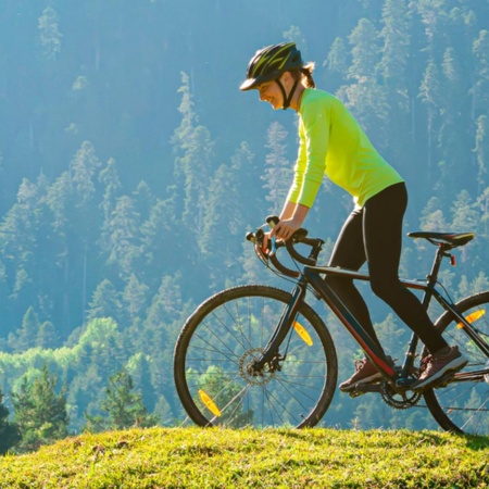 Mujer practicando cicloturismo en la naturaleza