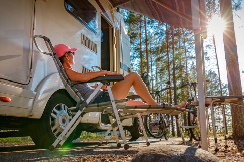 Tourist entspannt sich neben seinem Wohnwagen