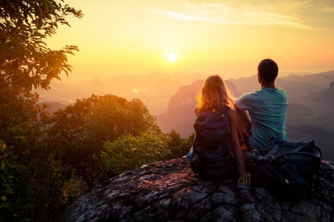 Casal admirando o entardecer na montanha