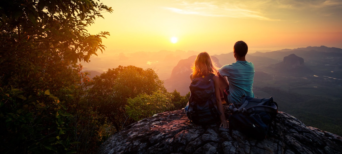 Pareja viendo el atardecer en la montaña