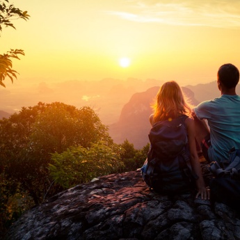 Pareja viendo el atardecer en la montaña