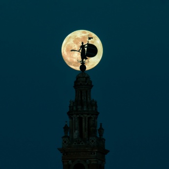 Silhouette der Giralda mit dem Vollmond in Sevilla, Andalusien