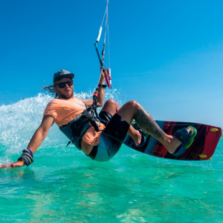 Jeune faisant du kite dans des eaux cristallines