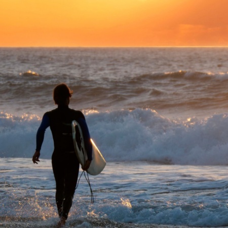 Surfer podziwiający zachód słońca na Fuerteventurze na Wyspach Kanaryjskich