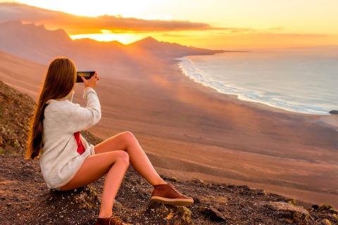 Une jeune fille prend des photos sur la plage de Cofete, Fuerteventura