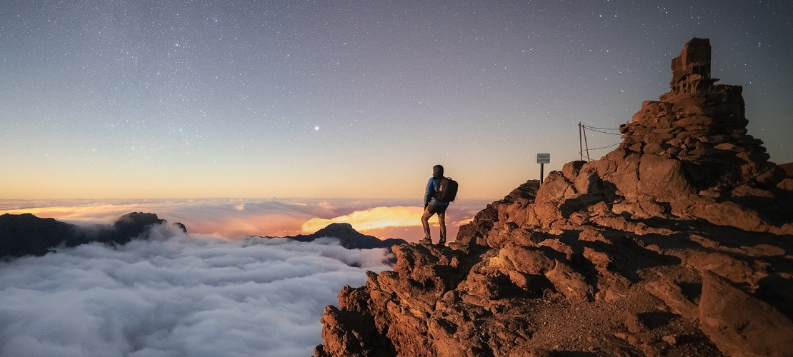 Tourist contemplating the sky from the viewpoint on the peak of Fuente Nueva in La Palma, Canary Islands