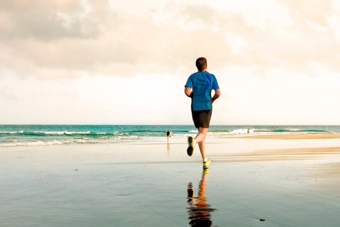 Giovane che corre sulla spiaggia di Maspalomas a Gran Canaria, isole Canarie