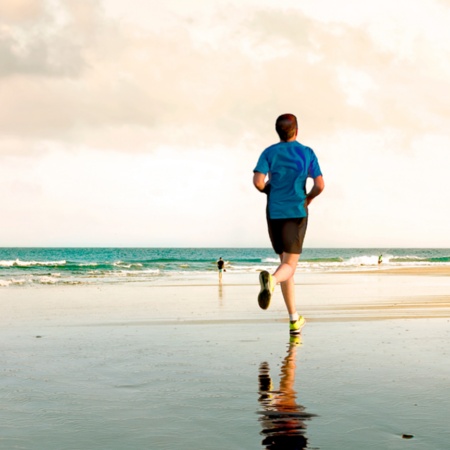 Young person running on Maspalomas beach in Gran Canaria, Canary Islands