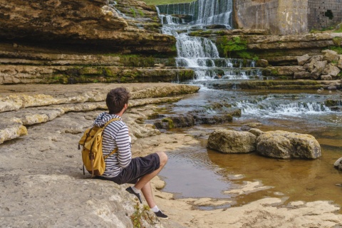 Turista contemplando la cascada del Bolao en Toñanes, Cantabria