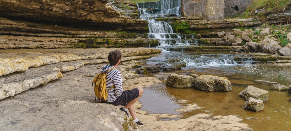 Turista contemplando la cascada del Bolao en Toñanes, Cantabria