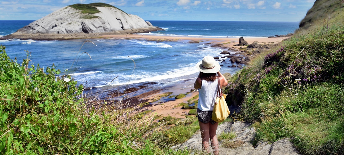 Turista tirando uma foto da praia de Covachos, em Liencres, Cantábria