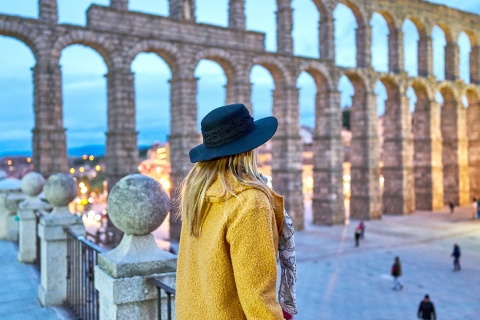 Chica joven contemplando el acueducto romano de Segovia