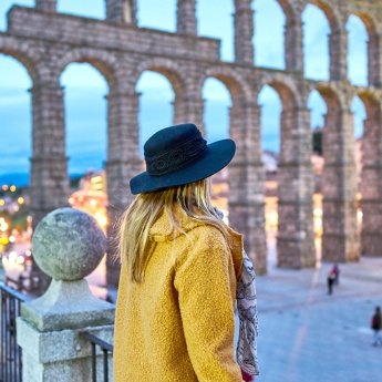 Chica joven contemplando el acueducto romano de Segovia