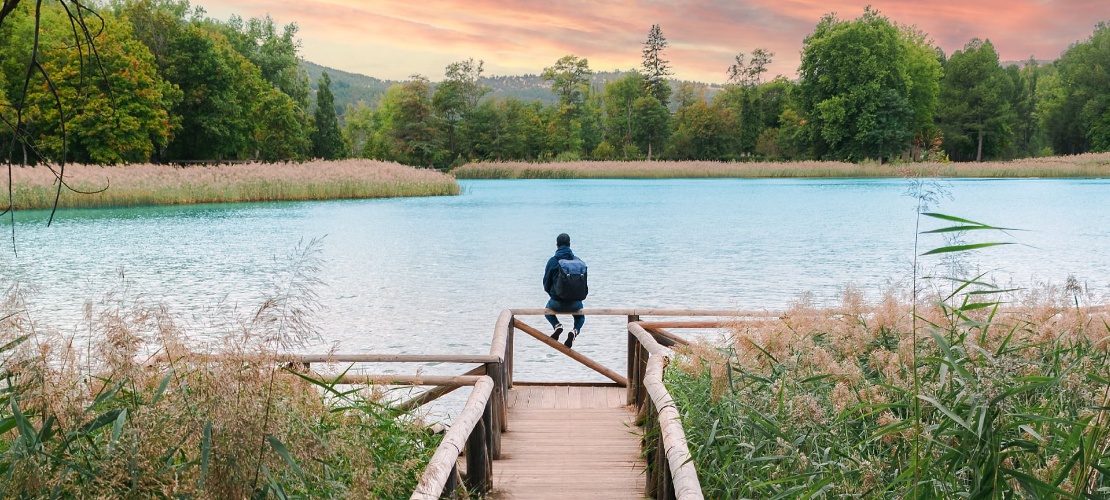 Turista contemplando la laguna de Uña en el Parque Natural de la Serranía de Cuenca, Castilla-La Mancha