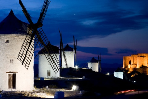 Widok nocą na wiatraki z zamkiem w Consuegra w tle. Toledo