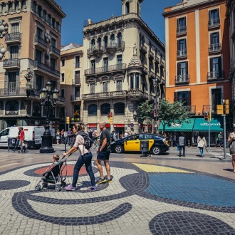 Ludzie przechodzący obok mozaiki Miró na Las Ramblas. Barcelona