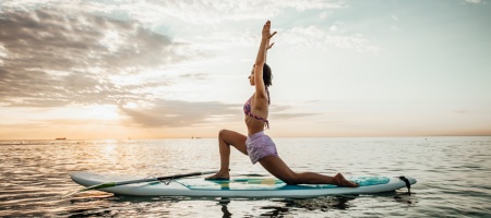 Mujer haciendo yoga en una tabla Sup