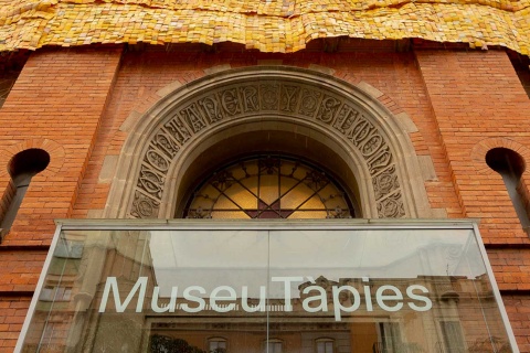 Fasada Museu Tàpies z instalacją „Més enllà de la pell” („Poza skórą”) autorstwa Serge Attukwei Clotteya, Barcelona, ​​​​2024