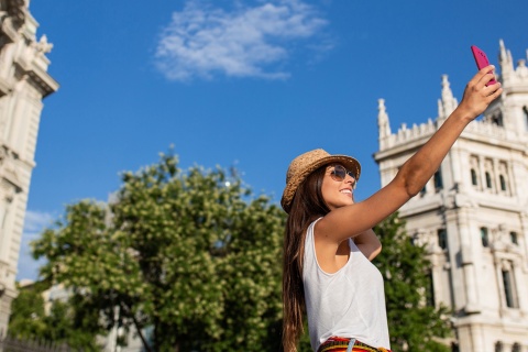 Touriste faisant un selfie sur la place de Cibeles à Madrid