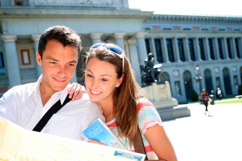 Tourists looking at a map of Madrid by the Prado Museum