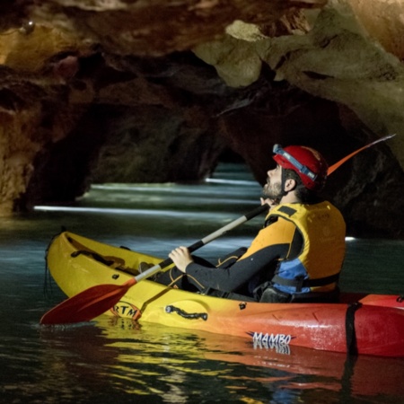 Turysta uprawiający kajakarstwo jaskiniowe w Coves de Sant Josep w La Vall d