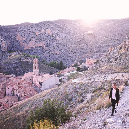 Wanderer auf einem Hügel mit Blick auf das Dorf Albarracín, Teruel