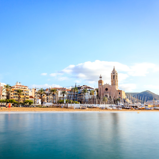 Vistas de la playa de Sitges y de la iglesia de Sant Bartomeu, situada en el puerto de Sitges