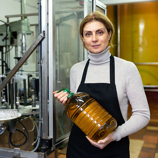 Donna in una fabbrica di olio che mostra un fiasco