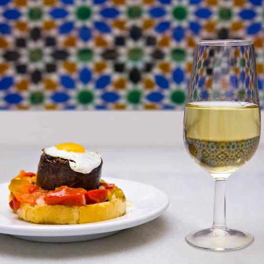 Tapa acompañado de vino blanco en Sevilla