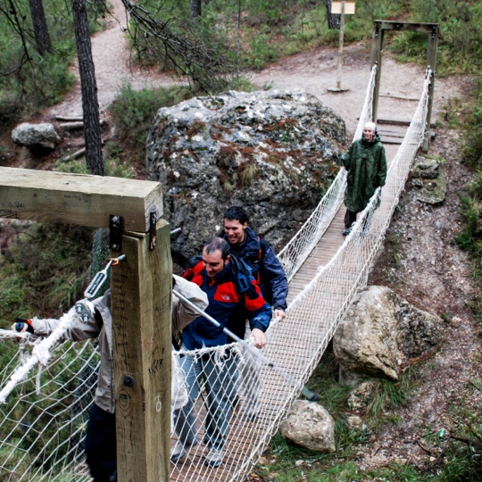 Excursionistas cruzando el puente colgante de camino a la Senda del Dinosaurio, Murcia