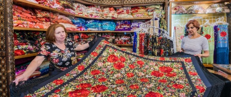 A woman buying a Manila shawl in a shop in Seville