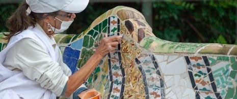 Woman restoring a balcony in Park Güell, Barcelona