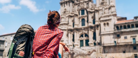 Osoba po pokonaniu szlaku Camino de Santiago przed katedrą w Santiago de Compostela 