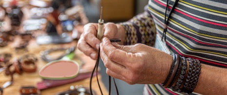 Artesano haciendo pulseras de cuero