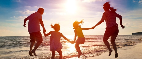 Familia divirtiéndose en la playa al atardecer