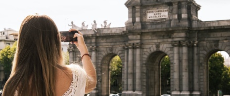 Tourist fotografiert die Puerta de Alcalá in Madrid, Region Madrid