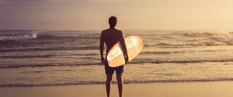 Surfista che contempla le onde dalla riva