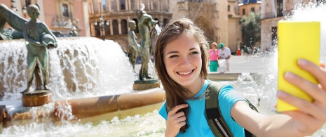 Turista na fonte da Plaza de la Virgen em Valência, Comunidade Valenciana