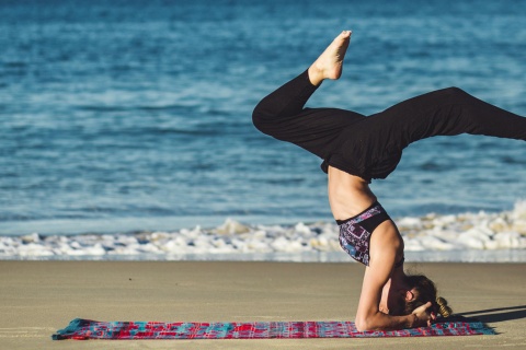 Girl practising yoga on the beach