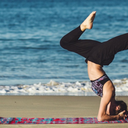 Girl practising yoga on the beach