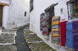 Typisch geschmückte Straße in Pampaneira (Granada) mit den traditionellen Decken der Alpujarra