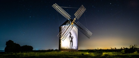 Starry night in Castilla-La Mancha with an image of Don Quixote reflected on a windmill