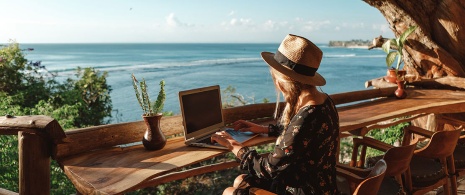 Girl working on a laptop by the sea