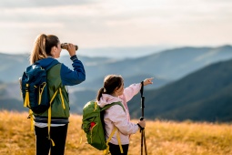 Mutter und Tochter gucken durch ein Fernrohr