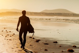 Un surfeur à Lanzarote au coucher du soleil